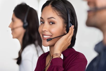 customer support center employee smiling because she's using demand driven customer service methods